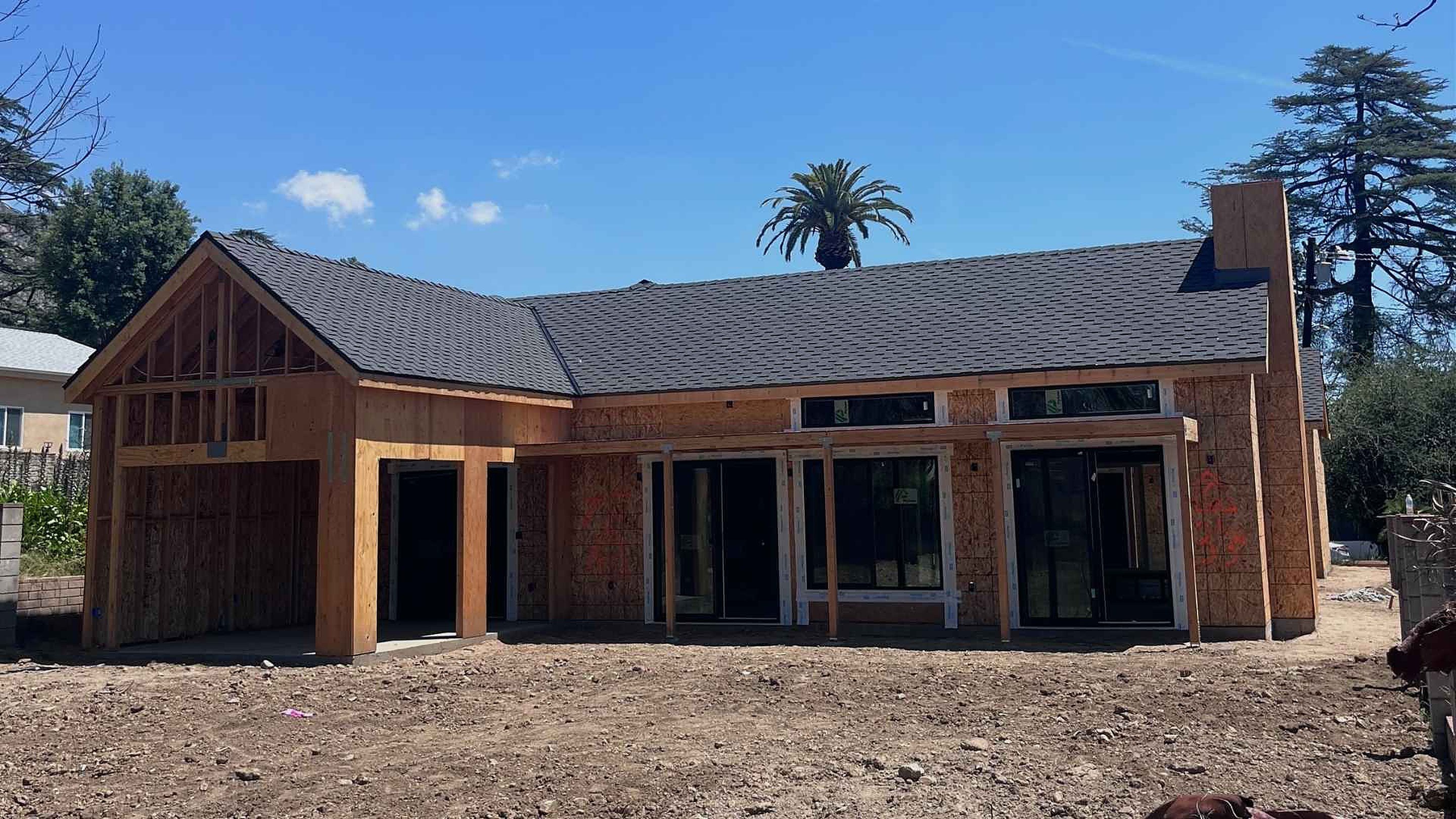 Altadena home under reconstruction — framed structure with completed roof, an active ATP rebuild